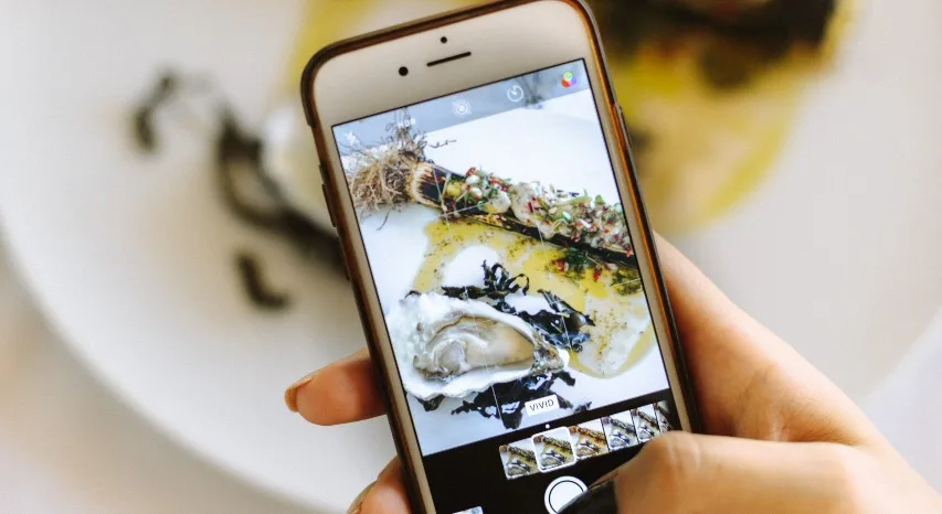 person taking photo of food on an iphone