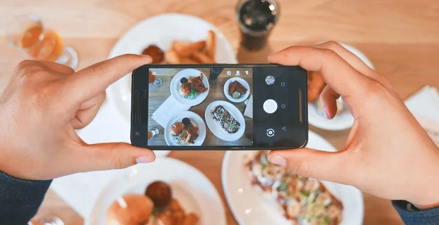 person taking photo of food on iphone